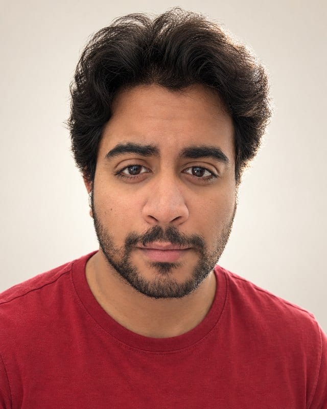 Portrait of Javeed Mohammad, smiling slightly, in a red T-shirt